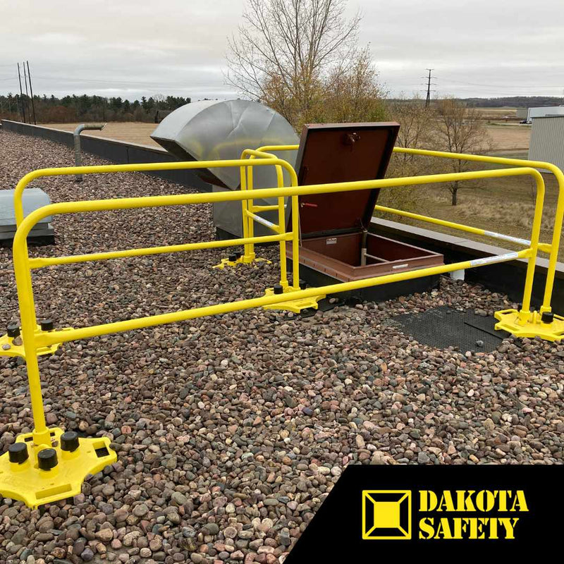 SafetyRail 2000 OSHA-compliant yellow guardrail system installed on rooftop around access hatch, showing non-penetrating base plates