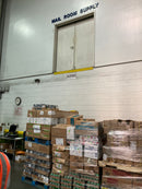 Closed upper-level double doors above pallet storage in a warehouse mail-room supply area.